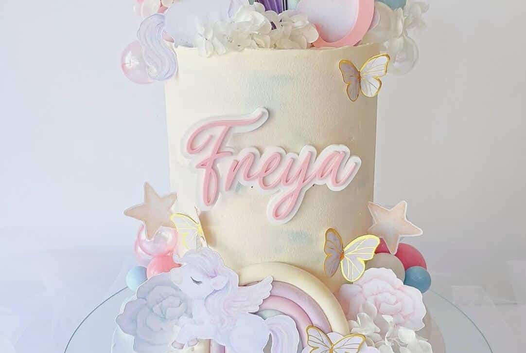Colorful unicorn-themed birthday cake featuring a double layered cake topper.