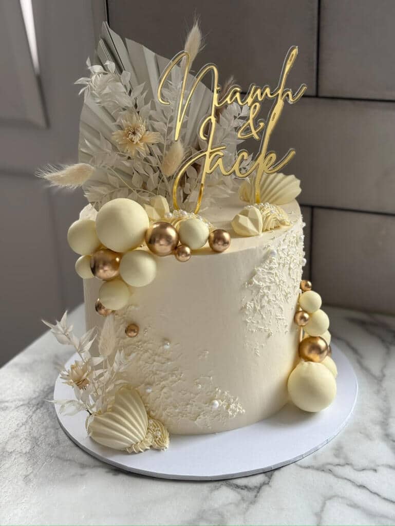 Elegant white wedding cake with gold accents.